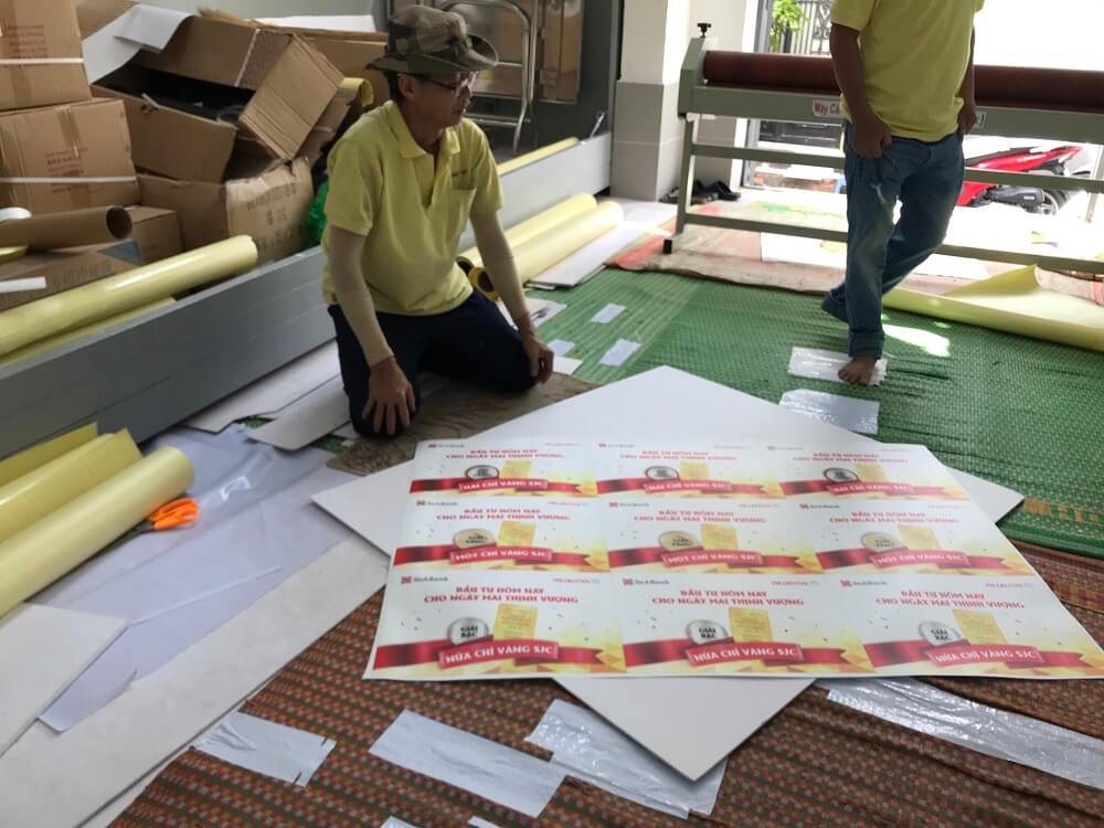 Nhân viên gia công hàng in banner cầm tay - bảng trao giải thường - loại hình in PP cán format